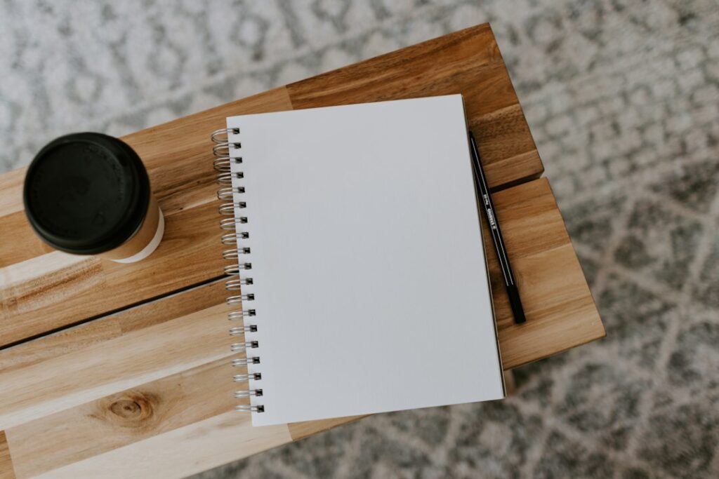 Blank notebook and pen on a wooden bench, ready for writing an ADHD dopamine menu
