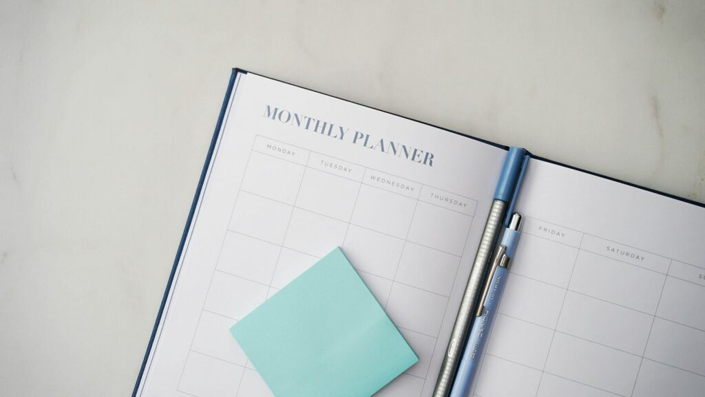 Open planner with a pen, used to chart symptoms across the menstrual cycle