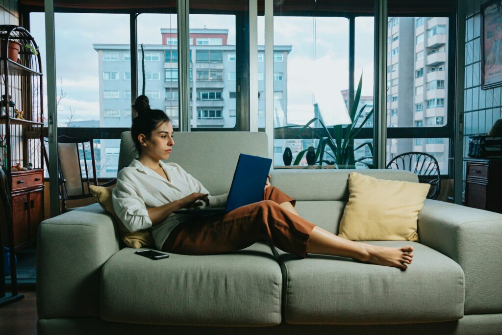 Woman relaxing on a sofa while using a tablet