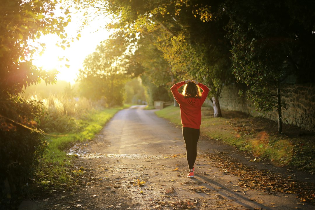 Person walking outdoors on a quiet country road in the morning, illustrating simple wellness habits trending in 2026